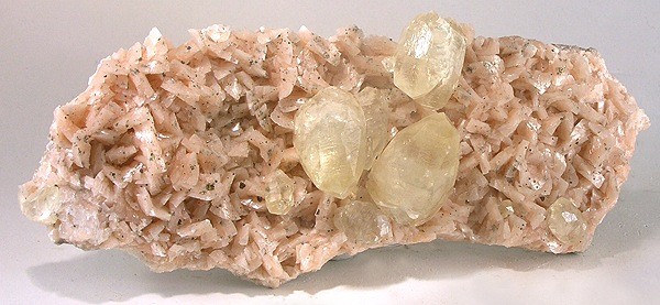 Large example of pink dolomite with three quartz crystals growing from it
